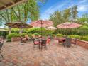 Outdoor patio featuring brick pavers, dining tables, and umbrellas, perfect for entertaining at 595 W Lake Ave, Littleton, CO 80120