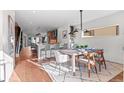 Open concept dining room with wood floors, modern lighting, and seamless flow to the kitchen at 2538 S Acoma St, Denver, CO 80223