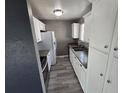 Galley kitchen with stainless appliances, gray counters, and white cabinets at 4247 S Pitkin St, Aurora, CO 80013