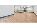 Open concept living space with hardwood floors and a view into the kitchen at 1112-1112 1/2 Krameria St, Denver, CO 80220
