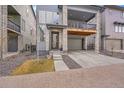 Exterior view of a gray three-story townhome featuring a front-facing two car garage at 15794 W Girard Ave, Morrison, CO 80465