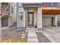 Close-up view of townhome front entrance showcasing rock accents and two-car garage at 15794 W Girard Ave, Morrison, CO 80465