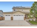 Home exterior showcases a three-car garage, stone accents, solar panels and a well-manicured front yard at 56579 E 23Rd Pl, Strasburg, CO 80136