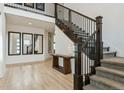 Bright foyer featuring a staircase with dark wood banister and iron balusters, wood floors, and tall ceilings at 303 Rogers Ct, Castle Rock, CO 80104