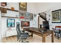 Bright home office with ample wall decor, shelving, a wooden desk, and French doors leading to the foyer at 303 Rogers Ct, Castle Rock, CO 80104