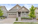 Charming home featuring a landscaped front yard, covered porch, and attached two-car garage at 757 Cabot Dr, Erie, CO 80516