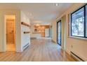 Open living area with wood floors, adjacent kitchen, and access to bathroom with glass shower at 1172 Juniper Ave, Boulder, CO 80304