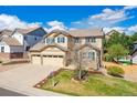 Beautiful two-story home with a well-maintained lawn, three-car garage, and classic architectural details at 10969 Valleybrook Cir, Highlands Ranch, CO 80130