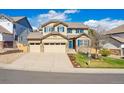 Attractive two-story home with a three-car garage, blue shutters, and a beautifully landscaped front yard at 10969 Valleybrook Cir, Highlands Ranch, CO 80130