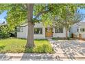 Charming single-Gathering home featuring a wood accent front door, landscaped yard, and a concrete driveway at 1732 Lansing St, Aurora, CO 80010