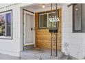 Charming wood accent front porch and entrance to the home, with a mailbox on the porch at 1732 Lansing St, Aurora, CO 80010