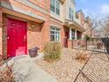 Townhome entrance featuring a red front door and low-maintenance gravel landscaping at 7323 Lowell Blvd, Westminster, CO 80030