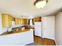 Efficient kitchen with light wood cabinetry, breakfast bar, and bright natural lighting at 5250 S Huron Way # 312, Littleton, CO 80120