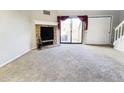 Cozy living room featuring a fireplace, plush carpeting, and sliding glass doors to balcony at 5250 S Huron Way # 312, Littleton, CO 80120