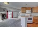 Open living room featuring a fireplace, plush carpeting, and view into kitchen area at 5250 S Huron Way # 312, Littleton, CO 80120