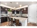 Modern kitchen featuring dark cabinetry, stainless steel appliances, granite countertops and an island with pendant lighting at 13326 Olive Way, Thornton, CO 80602
