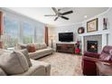 Comfortable living room with plush seating, a fireplace, and large windows for ample natural light at 13326 Olive Way, Thornton, CO 80602
