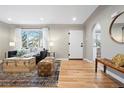 Living room features hardwood floors, large windows, and a view to the kitchen at 5231 Quitman St, Denver, CO 80212