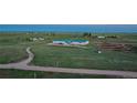 Aerial view of horse property showcasing multiple arenas and large stable at 27115 County Road 13, Elizabeth, CO 80107