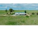 Aerial view of a two-story home with a walk-out, wraparound balcony and green roof at 27115 County Road 13, Elizabeth, CO 80107