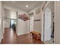 Bright entryway with hardwood floors, bench, and access to living spaces at 1005 Alpine Aven St, Henderson, CO 80640