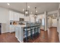 A well-equipped kitchen with an island and barstool seating, ideal for casual dining at 1005 Alpine Aven St, Henderson, CO 80640