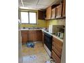 Image of kitchen with outdated appliances, yellow walls, and cluttered countertops at 3150 W 134Th Ave, Broomfield, CO 80020