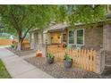 Charming brick home featuring a well-kept front yard, fence and inviting front porch at 9193 W 7Th Ave, Lakewood, CO 80215