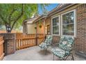 Inviting front porch with comfortable chairs and a charming fence with beautiful flowering plants at 9193 W 7Th Ave, Lakewood, CO 80215