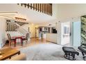 Spacious living room with vaulted ceiling, white staircase, and hardwood floors transitioning to carpet at 461 S Kalispell Way # D, Aurora, CO 80017