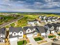 A panoramic view of a neighborhood with modern homes, green spaces, and a distant lake at 9374 Quartz St, Arvada, CO 80007