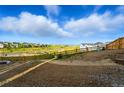 Spacious, undeveloped backyard featuring new wood fence and panoramic views of the surrounding landscape and community at 9374 Quartz St, Arvada, CO 80007
