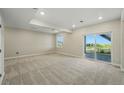 Bright living room featuring neutral carpeting, recessed lighting, and sliding glass door with backyard access and scenic views at 9374 Quartz St, Arvada, CO 80007
