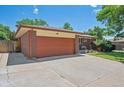 Spacious garage with an extended driveway and well-maintained landscaping at 1774 S Dover Way, Lakewood, CO 80232