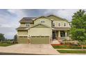 Two story home with a two-car garage, inviting porch, and manicured lawn at 23503 E Minnow Dr, Aurora, CO 80016