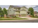 View of the front of the home, featuring a two-car garage and nicely landscaped yard at 23503 E Minnow Dr, Aurora, CO 80016