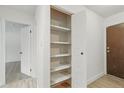 Hallway closet with shelving for ample storage and an entrance door at 7755 E Quincy Ave # 107D2, Denver, CO 80237
