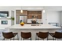 Stylish kitchen showcasing stainless steel appliances, wood cabinets, island, and modern pendant lighting at 5531 W 11Th Pl, Lakewood, CO 80214