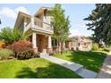 Beautiful two-story brick home featuring a balcony, covered porch, and well-maintained front lawn at 1265 S Sherman St, Denver, CO 80210