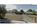 Street view of a property with a partially fenced yard and an unpaved driveway at 971 S Wolff St, Denver, CO 80219