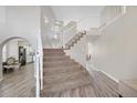 Bright foyer showcasing staircase, light wood floors, and an open layout leading to kitchen and living areas at 10058 Glenstone Cir, Highlands Ranch, CO 80130