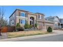 Beautiful two-story house featuring brick accents, manicured landscaping, and a spacious two-car garage at 10058 Glenstone Cir, Highlands Ranch, CO 80130