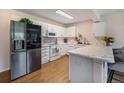 Modern kitchen featuring white cabinets, stainless steel appliances, and a marble countertop at 64 N Harlan St, Lakewood, CO 80226