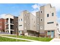 Modern townhome exteriors showcasing gray siding, brick accents, well-maintained lawns, and blue sky at 1238 Quitman St # 2, Denver, CO 80204