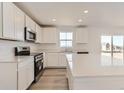 Bright kitchen with stainless steel appliances, quartz countertops, and stylish white cabinetry at 3919 N Shawnee St, Aurora, CO 80019