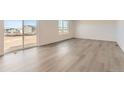 Bright living room featuring luxury vinyl plank flooring and a sliding glass door at 3919 N Shawnee St, Aurora, CO 80019