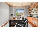 Well-lit home office featuring a large desk, comfortable chair, and view of the outside at 7367 S Tempe Ct, Aurora, CO 80016