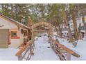 Romantic snow covered pathway with bridge and arch, leading through trees at 127 Shady Ln, Palmer Lake, CO 80133