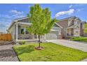 Inviting two-story home featuring a covered porch, well-kept lawn, and a two-car attached garage with a concrete driveway at 47349 Lily Ave, Bennett, CO 80102