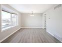 Bright dining room featuring gray laminate flooring and a large bay window at 3408 S Olathe Way, Aurora, CO 80013